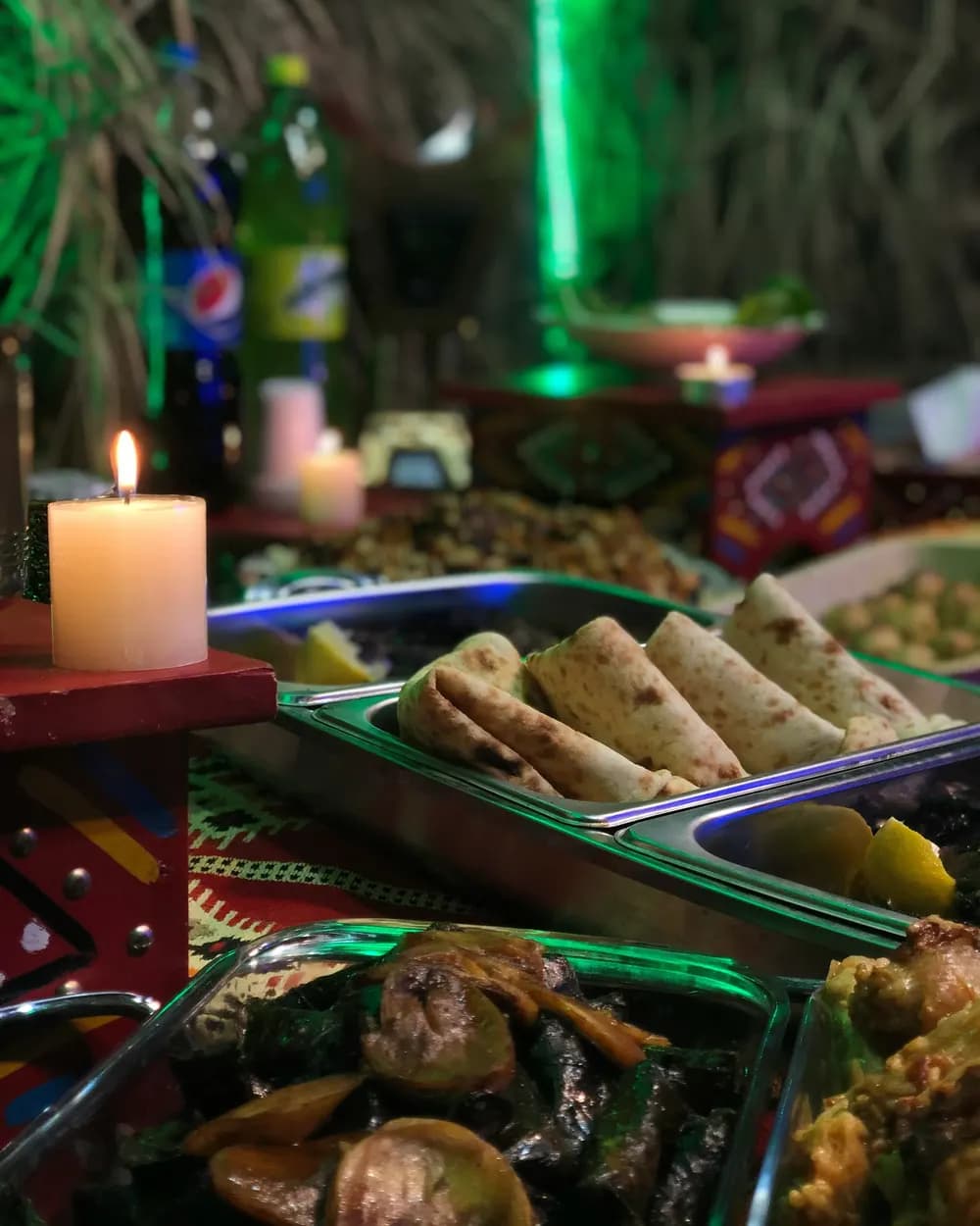 Restaurant table with chapati, stews and a lit candle