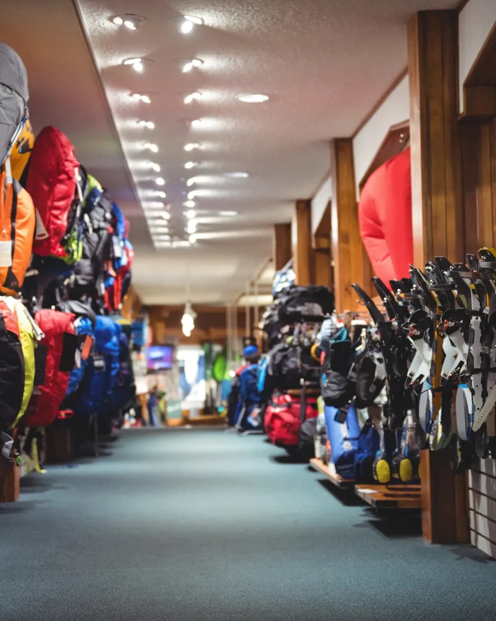 Aisle of a shop with backpacks and outdoor gear on both walls